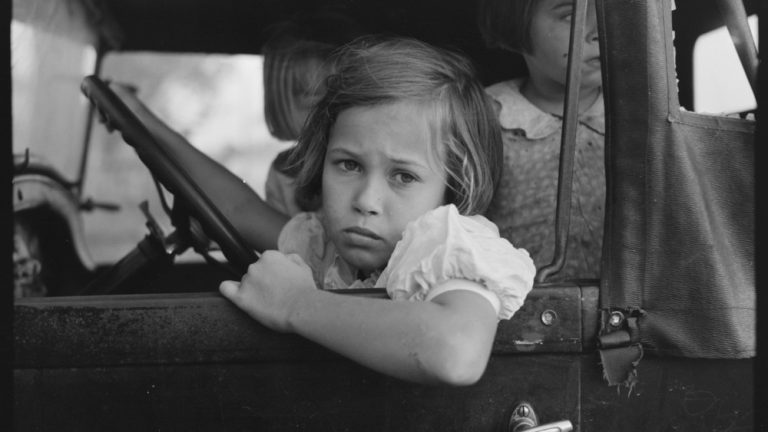Child of farmer sitting in automobile waiting for father to come out of general store, Jarreau, Louisiana by Russell Lee. Unknown date - USA