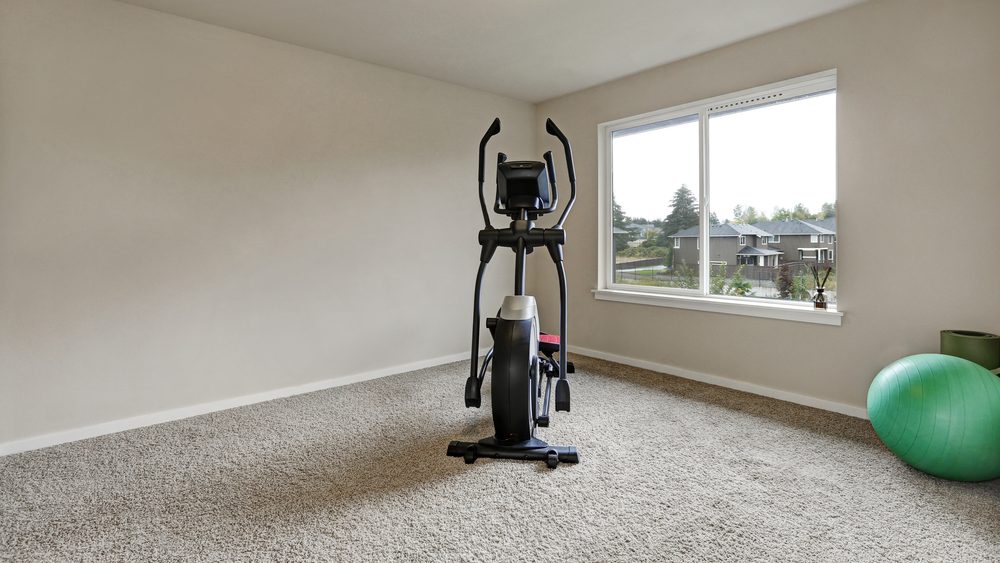 Beige interior of small home gym with sport equipment . Northwest, USA