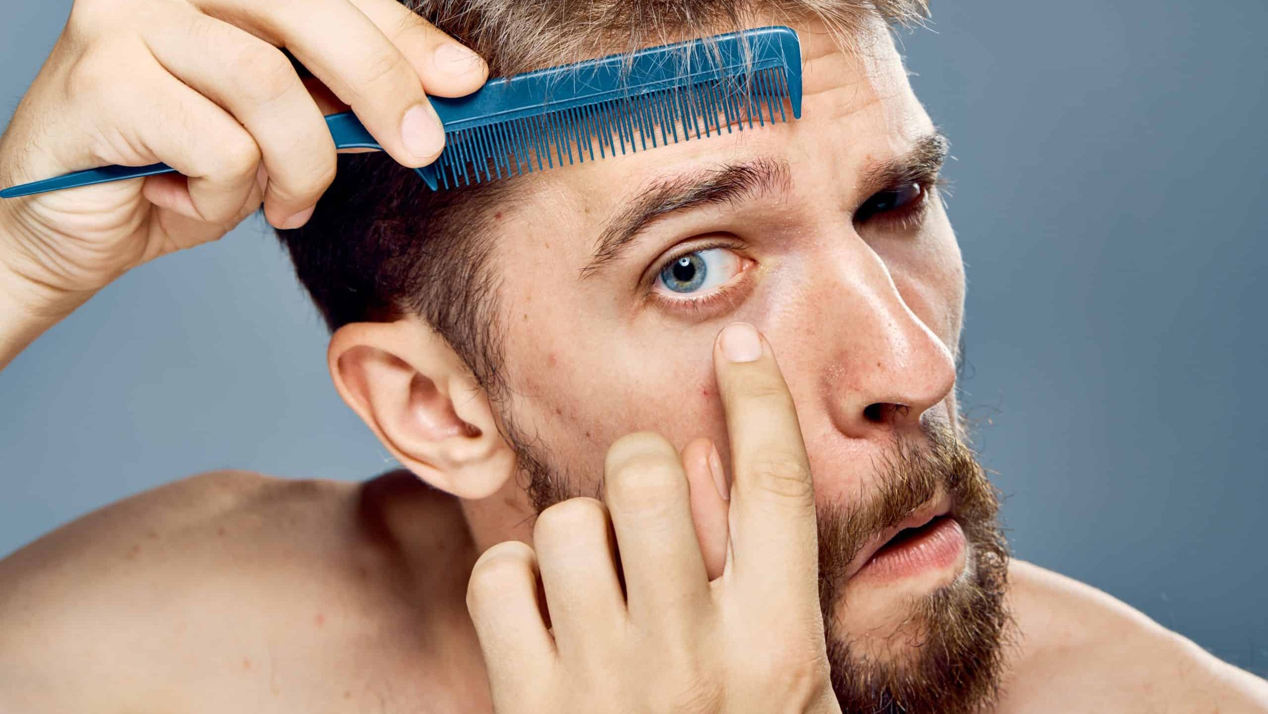 man combs his eyebrows, portrait, close-up.