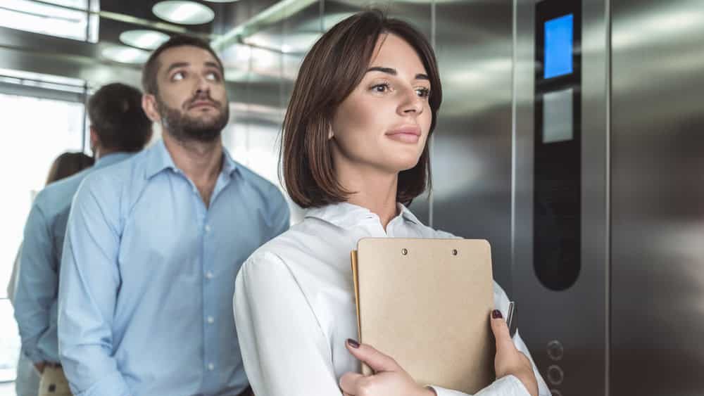 Business couple is rising in elevator