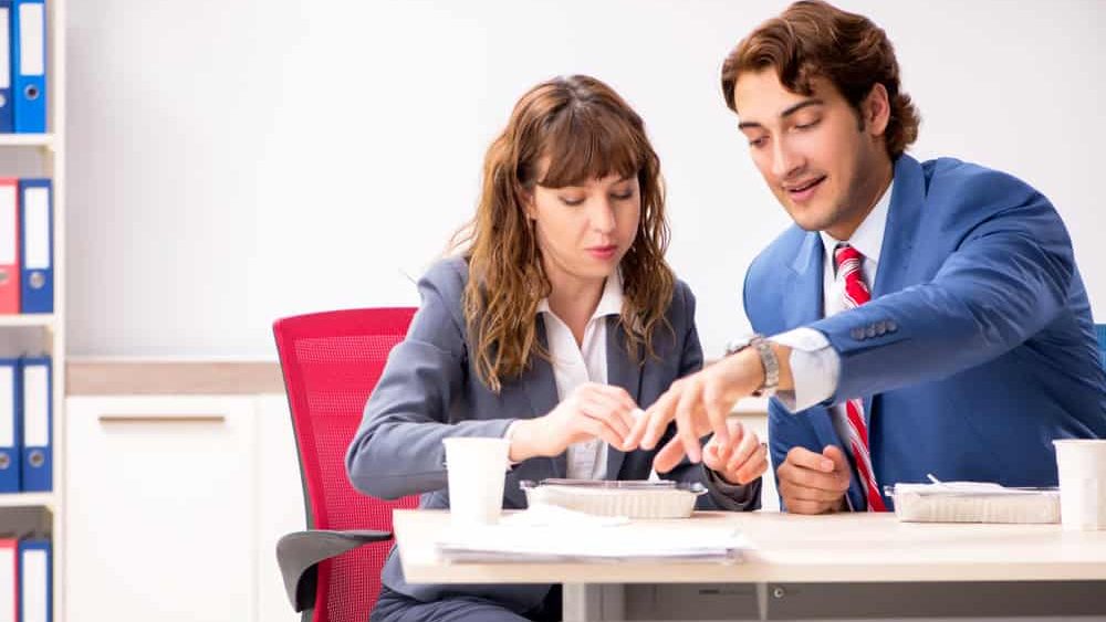 Two colleagues having lunch break at workplace