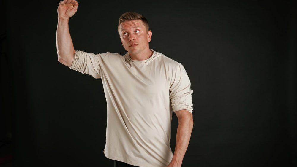 Height measurement by hand, look at this. Man is against background in the studio.