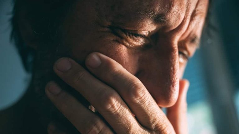 Emotional distraught sad man crying stressed, dealing with mental health problems, depression, anxiety and despair, selective focus