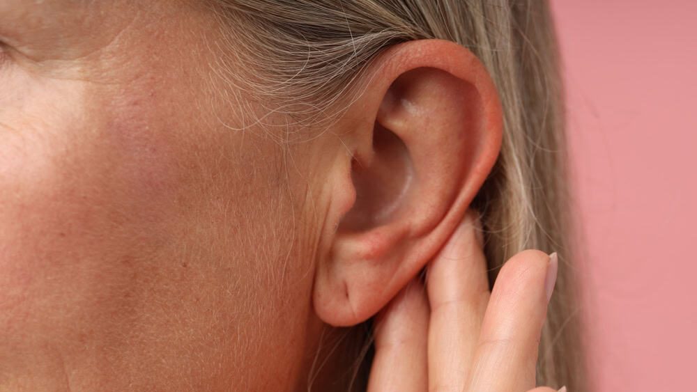 Sound.,Senior,Woman,Touching,Her,Ear,On,Pink,Background,,Closeup