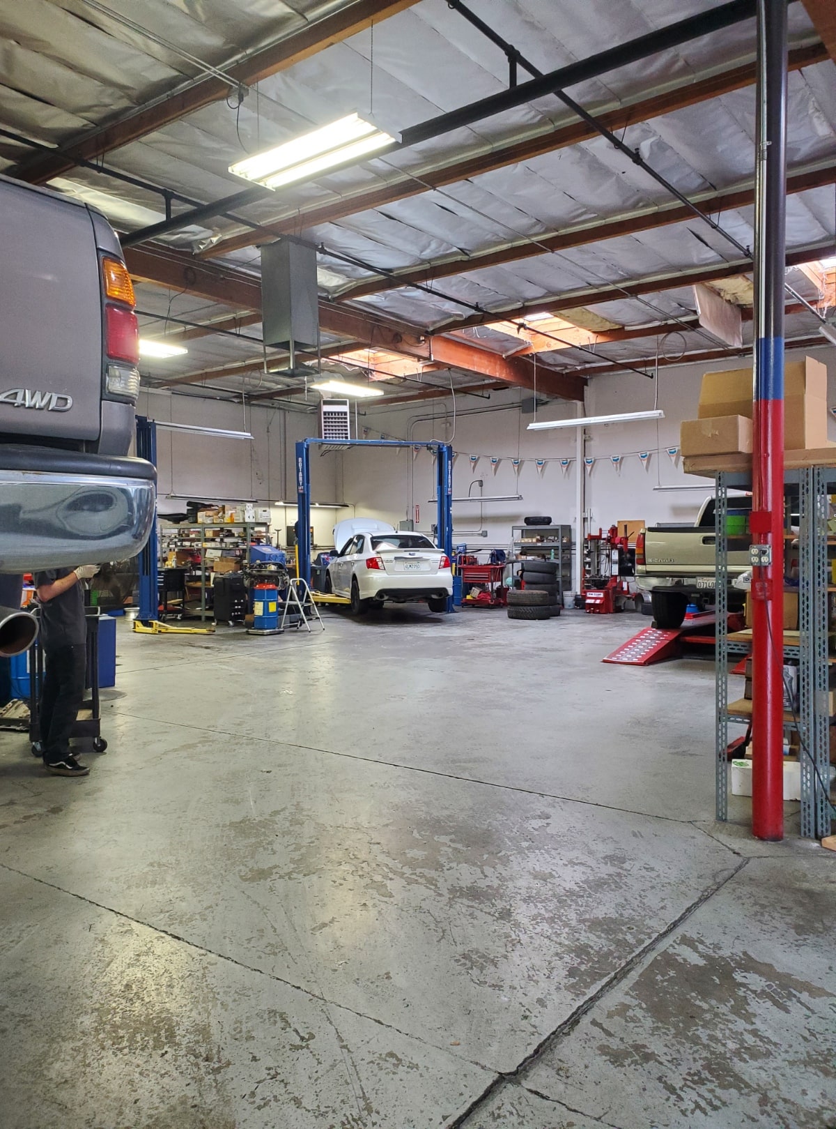 Auto repair shop interior with vehicles, tools, and repair equipment for vehicle maintenance and ser.
