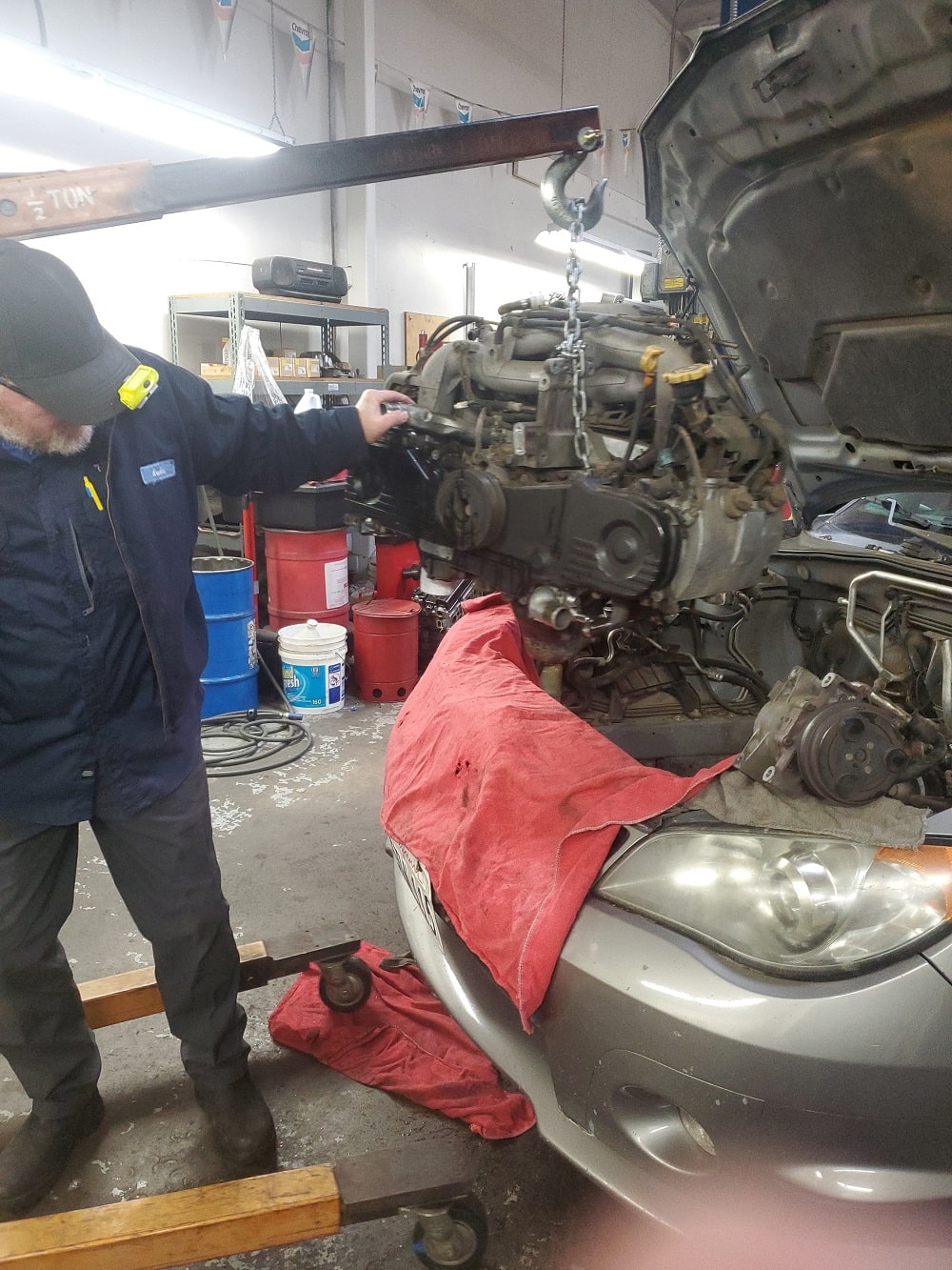 Skilled mechanic repairing car engine in auto repair shop.