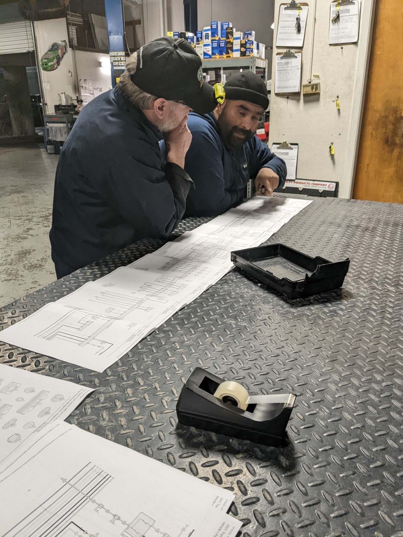 Experienced technicians discussing vehicle repair plans.
