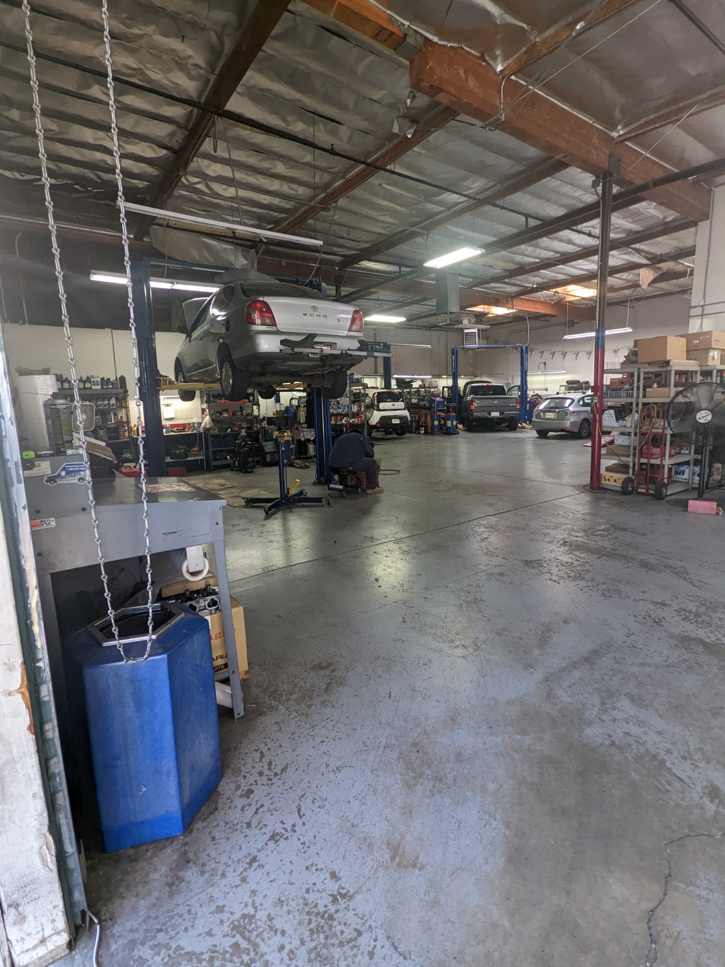 Auto repair shop interior with cars on lifts, tools, and workstations for vehicle maintenance and re.