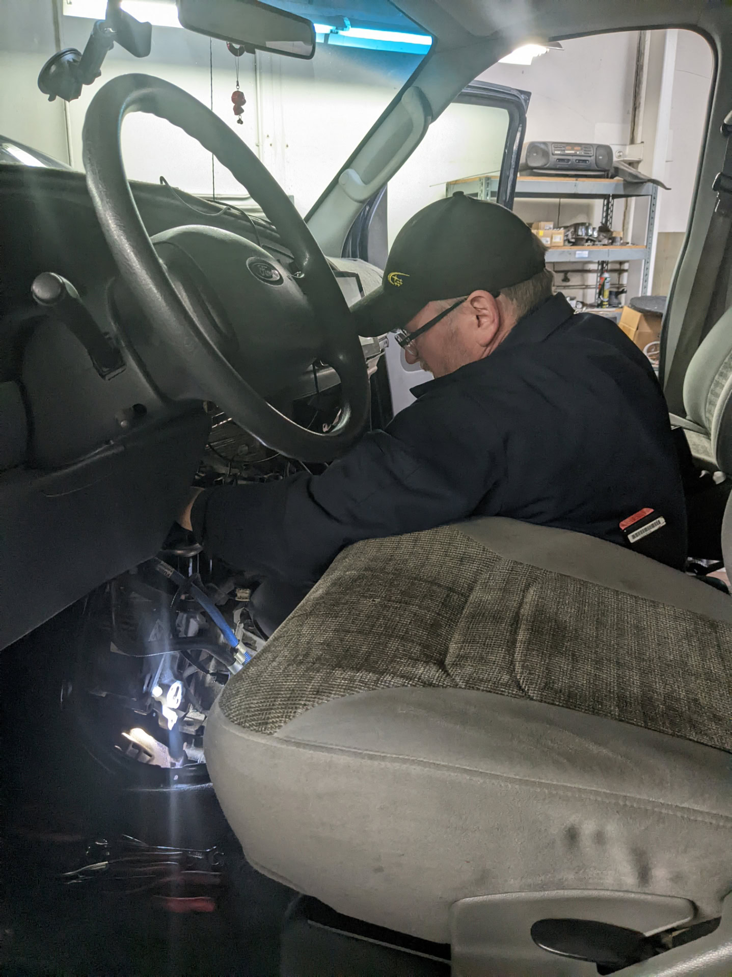 Automotive technician inspecting vehicle interior for repairs at Auburn Service Center.