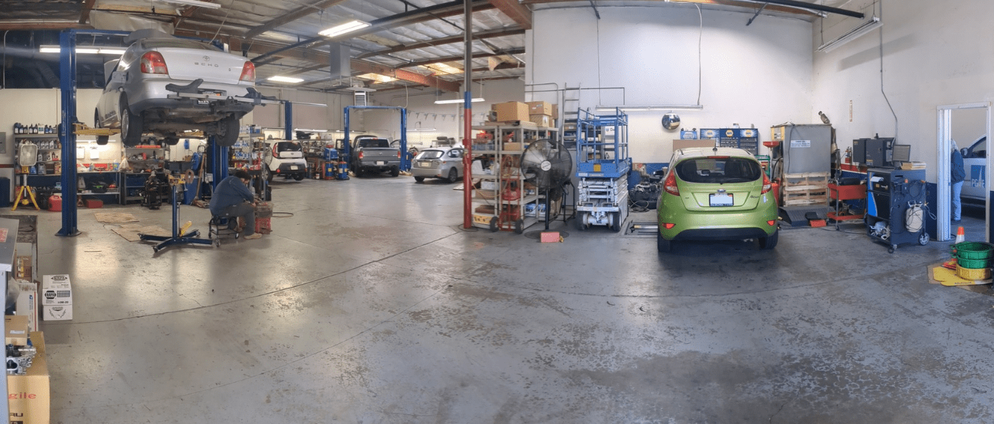 Interior view of Auburn Service Center auto repair shop with vehicles and equipment.
