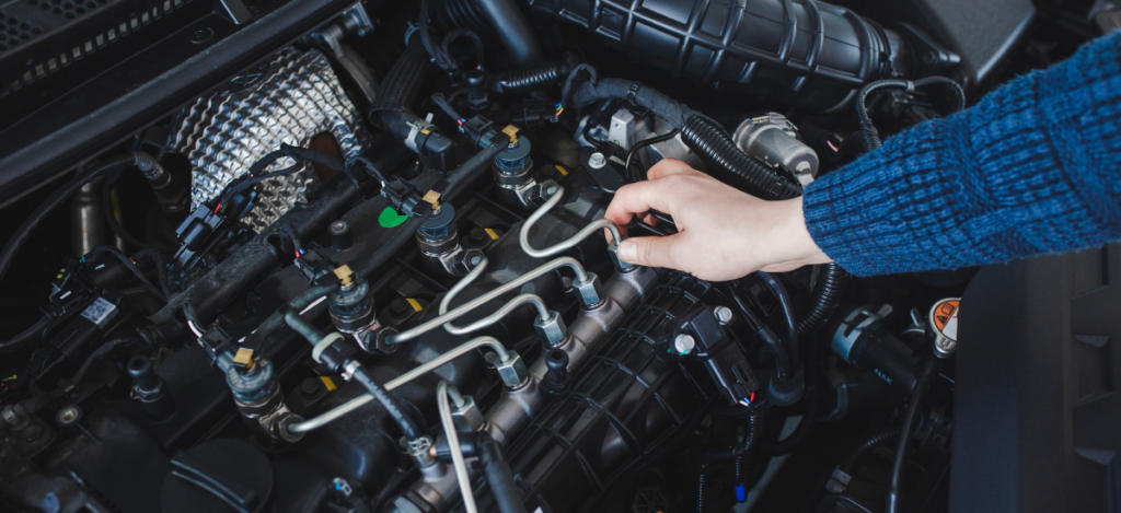 Technician inspecting a car engine during routine maintenance at Auburn Service Center.