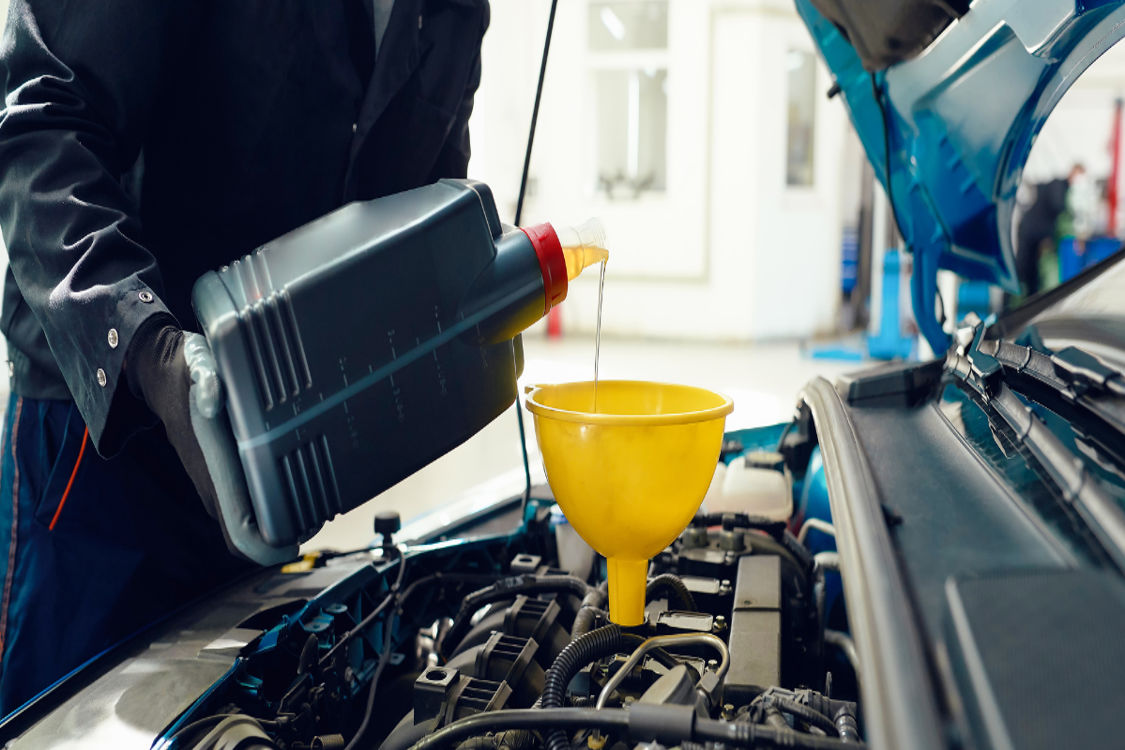 Engine oil being poured during a fluid exchange service.