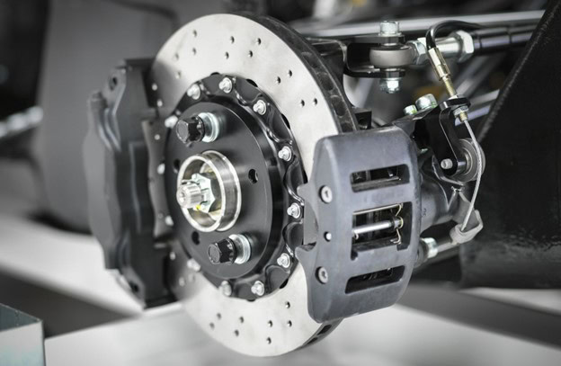 Brake system component with disc brake assembly and hydraulic lines.