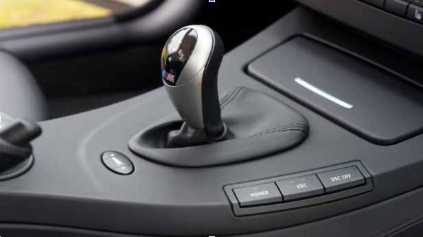 Close-up of manual transmission gear shift in a car interior.