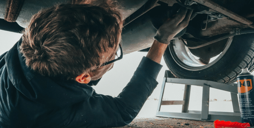 Mechanic inspecting car brakes and rotors for wear and damage.