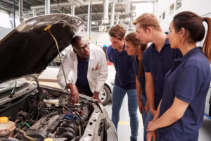 mechanic-instructing-trainees-around-engine-car