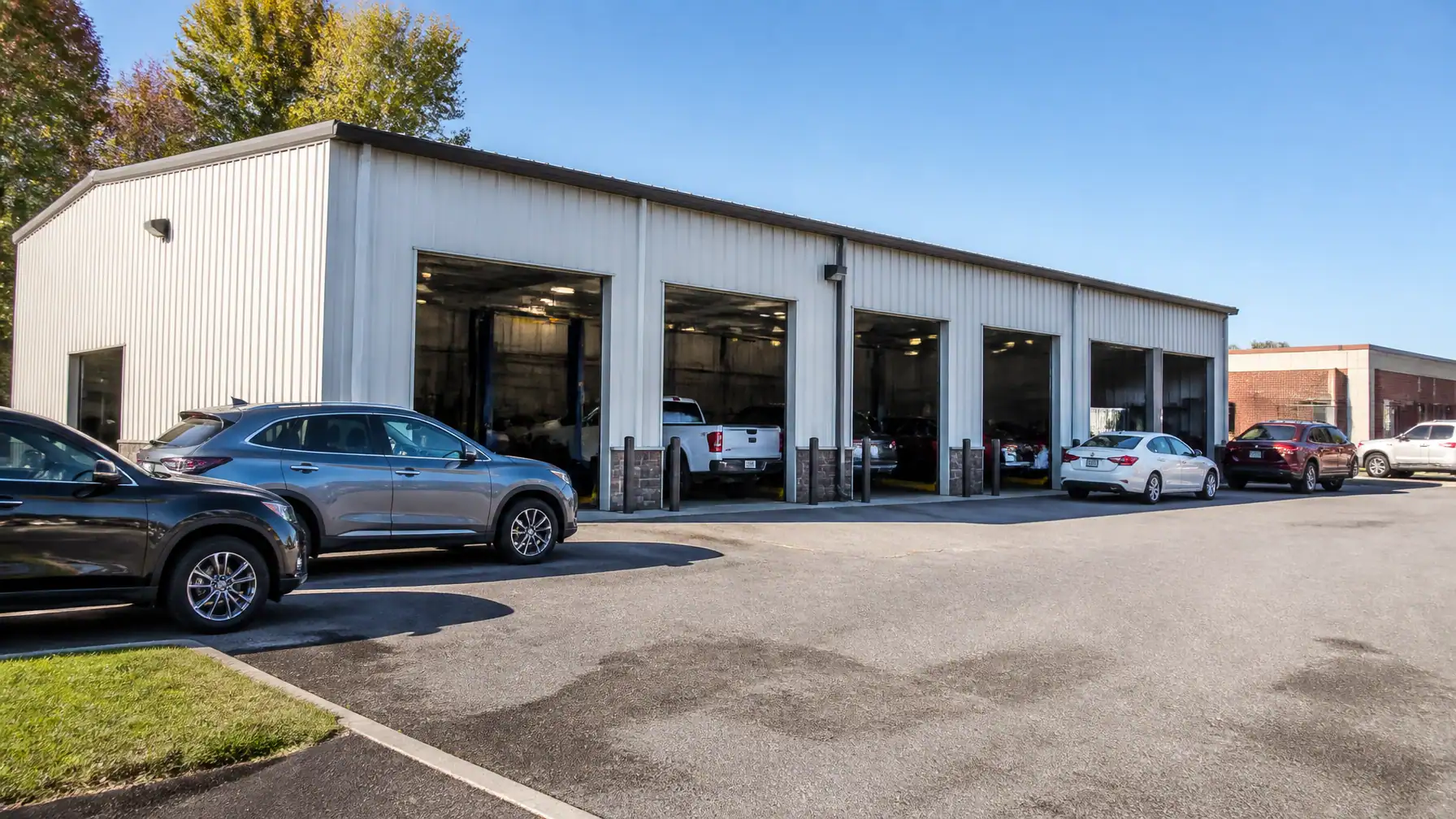 Auto repair shop with multiple service bays and parked vehicles.