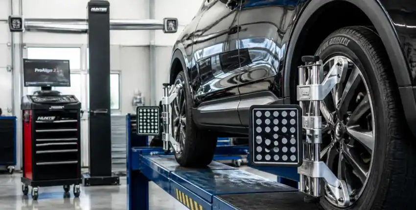 Car on lift during auto service at Autocenters with diagnostic tools.