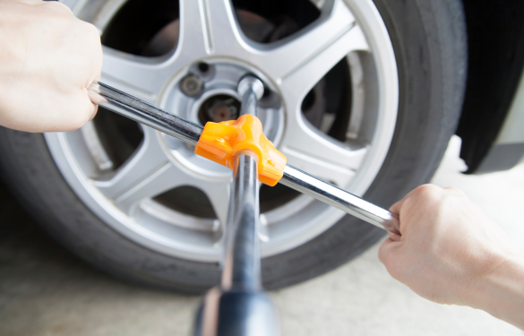 Professional lug nut removal and replacement on vehicle wheel.