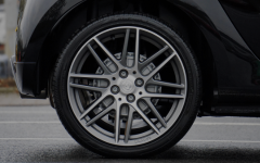 Close-up of stylish aftermarket tires and wheels on a black car.