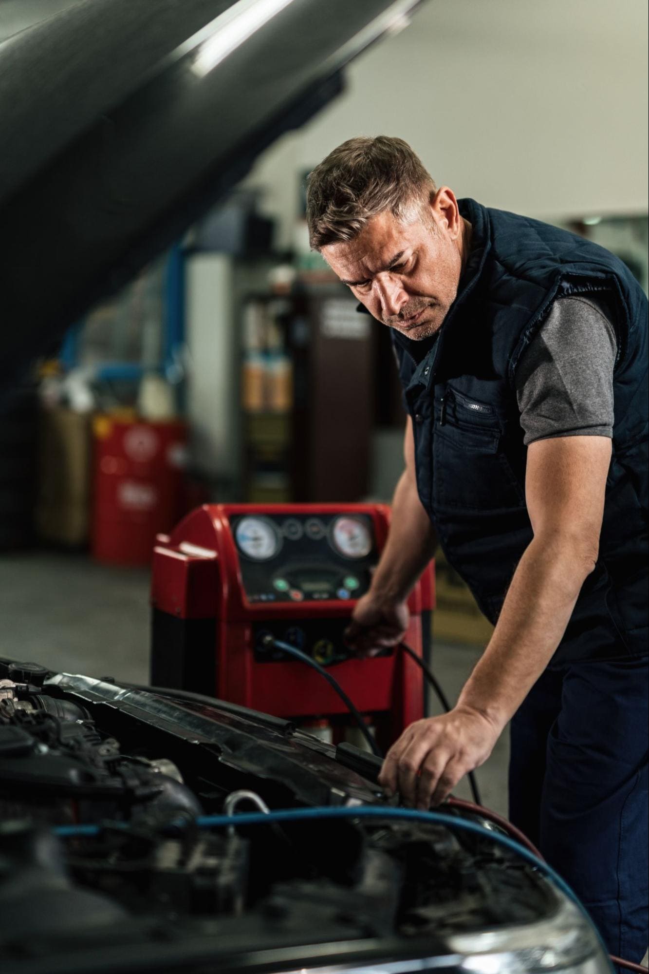 Automotive technician performing engine diagnostics with advanced equipment.