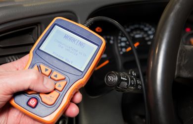 Diagnostic scanner checking vehicle engine performance.