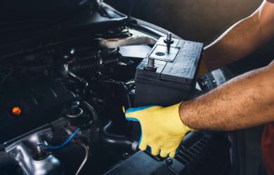Technician inspecting car engine during automotive repair at Big Sky Tire and Repair.