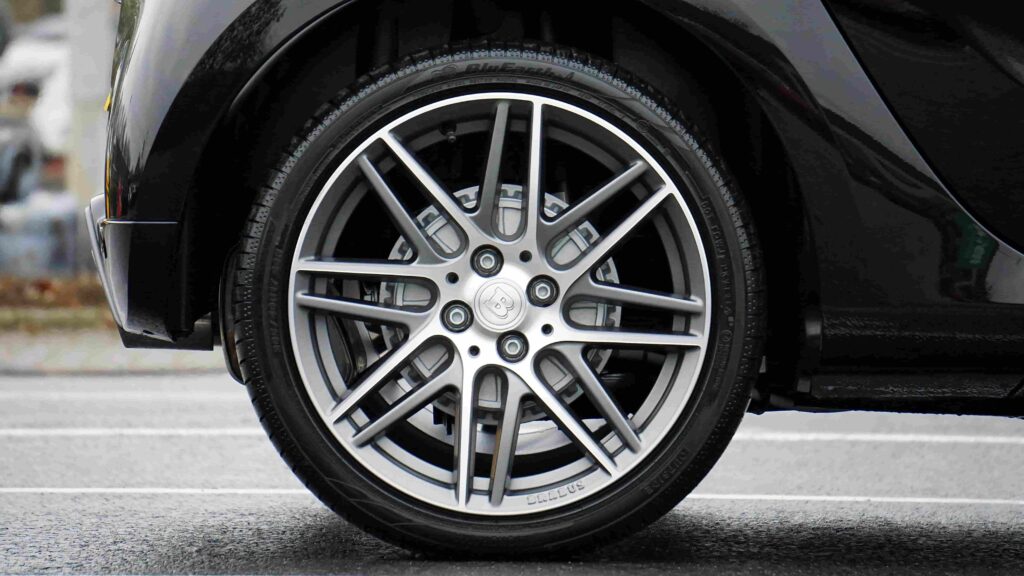 Close-up of a car tire showing tread wear and wheel details.