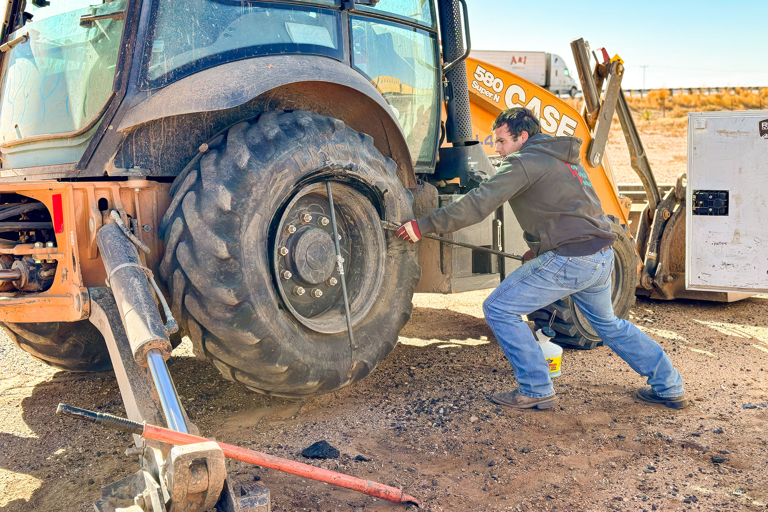 Technician inspecting large tractor tire at Big Sky Tire and Repair.