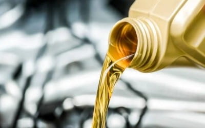 Motor oil pouring into car engine for maintenance or repair.