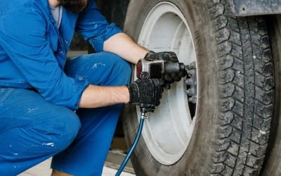 Technician repairing a truck tire with a pneumatic tool at Big Sky Tire and Repair.
