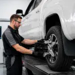 Technician inspecting a white truck's wheel at Big Sky Tire and Repair.