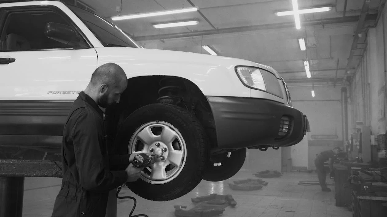 Technician inspecting a car tire for common issues at Black n Rounds ATX.