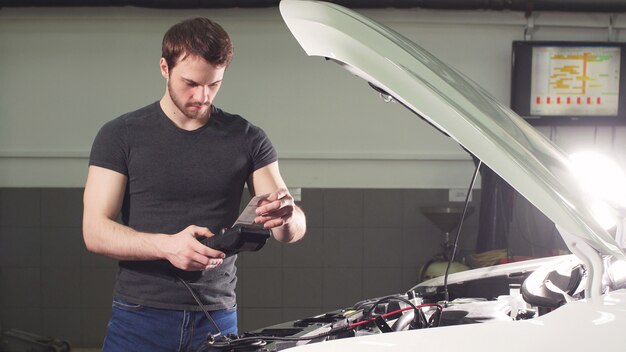 Technician using diagnostic tools to check vehicle wheel alignment.
