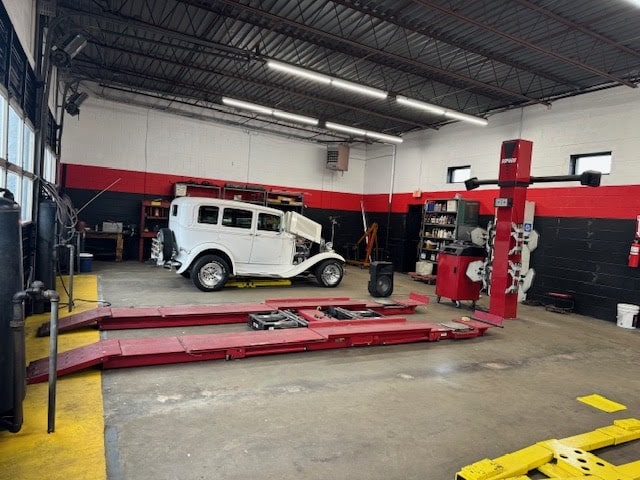 Auto repair shop with vintage car on lift for maintenance.