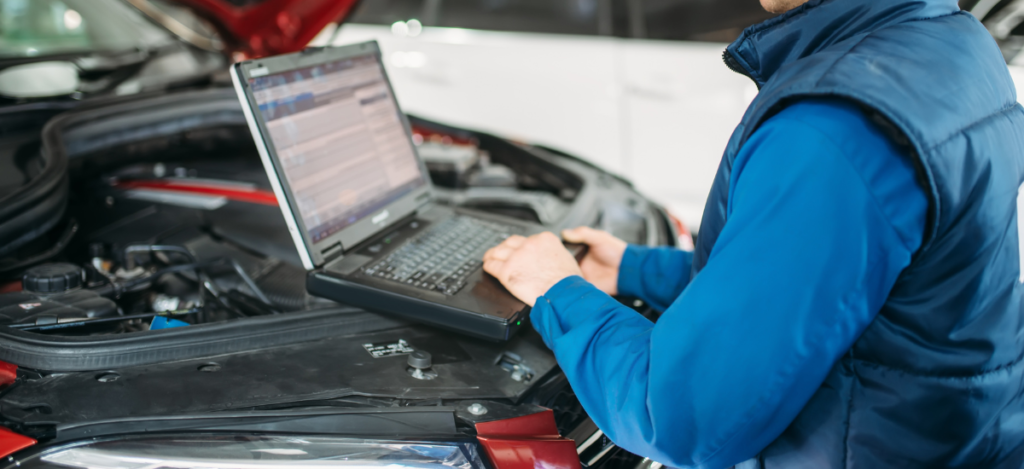 Auto repair technician diagnosing car issues with a laptop in Glen Burnie.