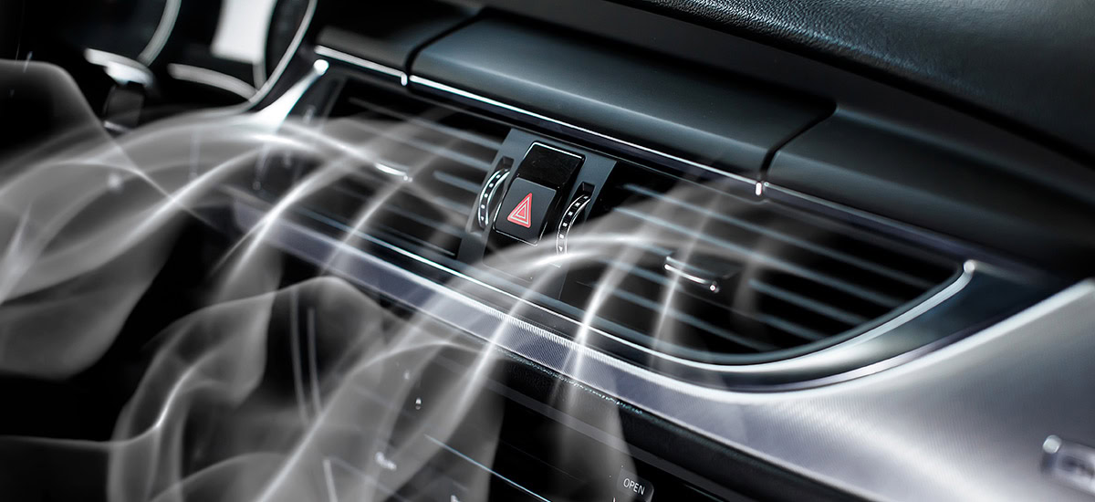 Car dashboard with air vents and airflow, emphasizing AC system care.