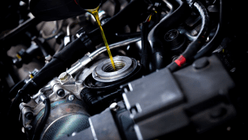 Engine oil being poured into a car engine for maintenance at Bluestone Automotive.