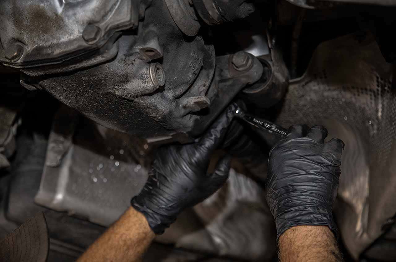Engine repair technician working on a vehicle's engine component.