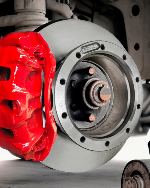 Close-up of a car brake disc and red brake caliper for European vehicles.