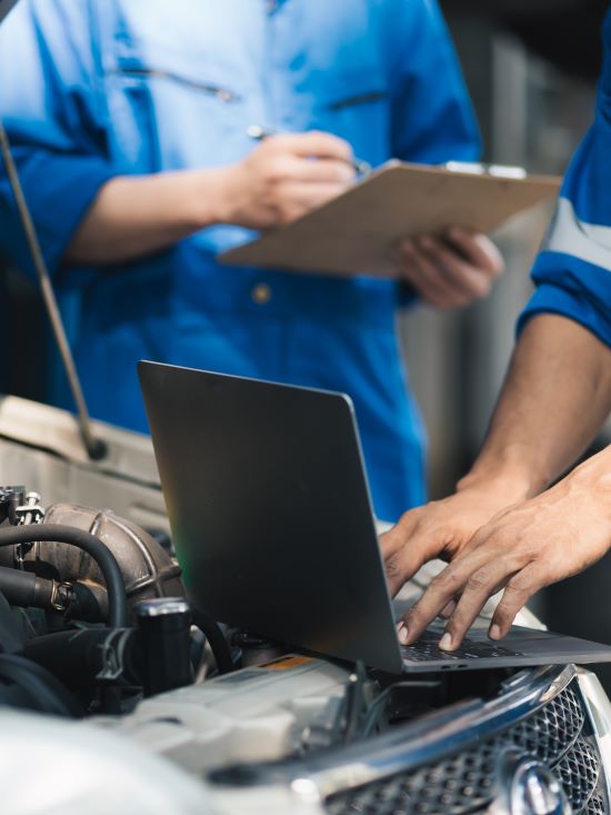 Technicians using a laptop for vehicle diagnostics at BMP Auto Service.