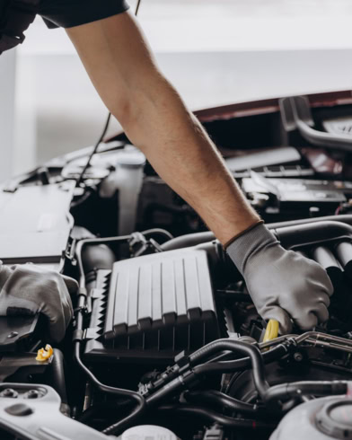 Technician inspecting car engine during repair at BMP Auto Service.