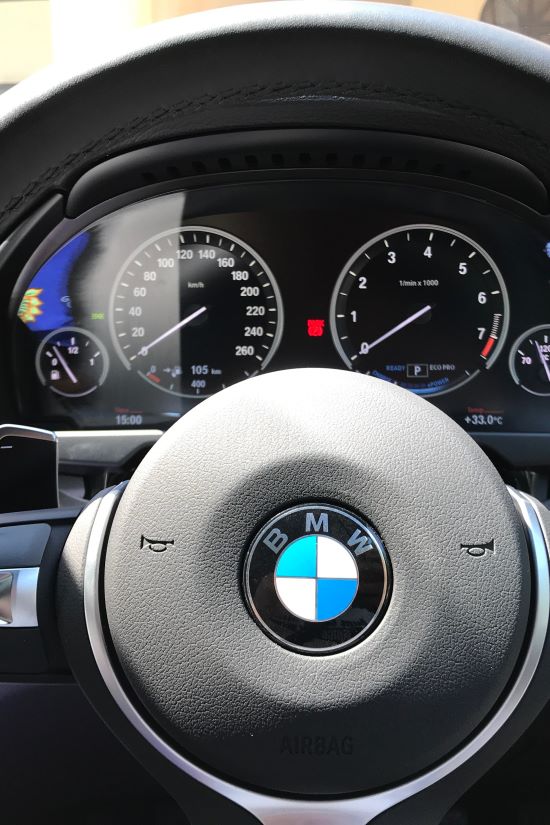 Close-up of BMW car dashboard showing speedometer and warning lights.
