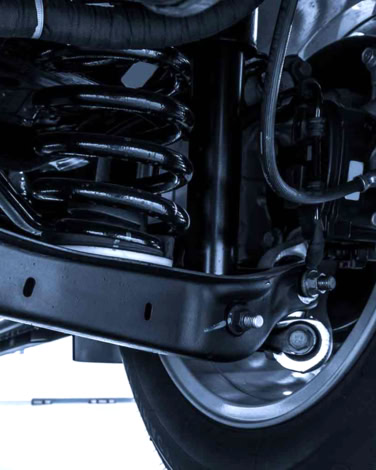 Close-up of vehicle suspension coil spring and shock absorber.