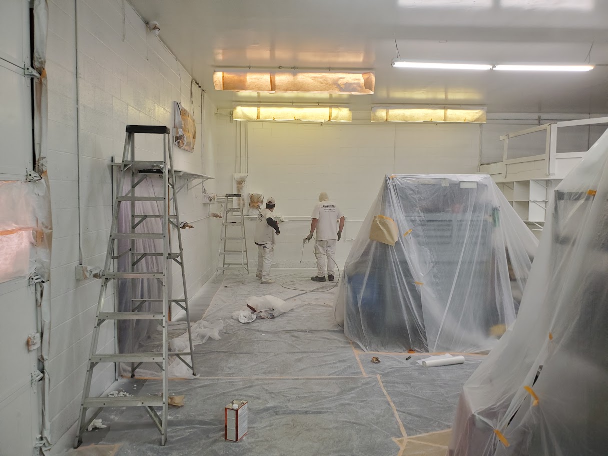 Auto repair shop with vehicles being painted or repaired.