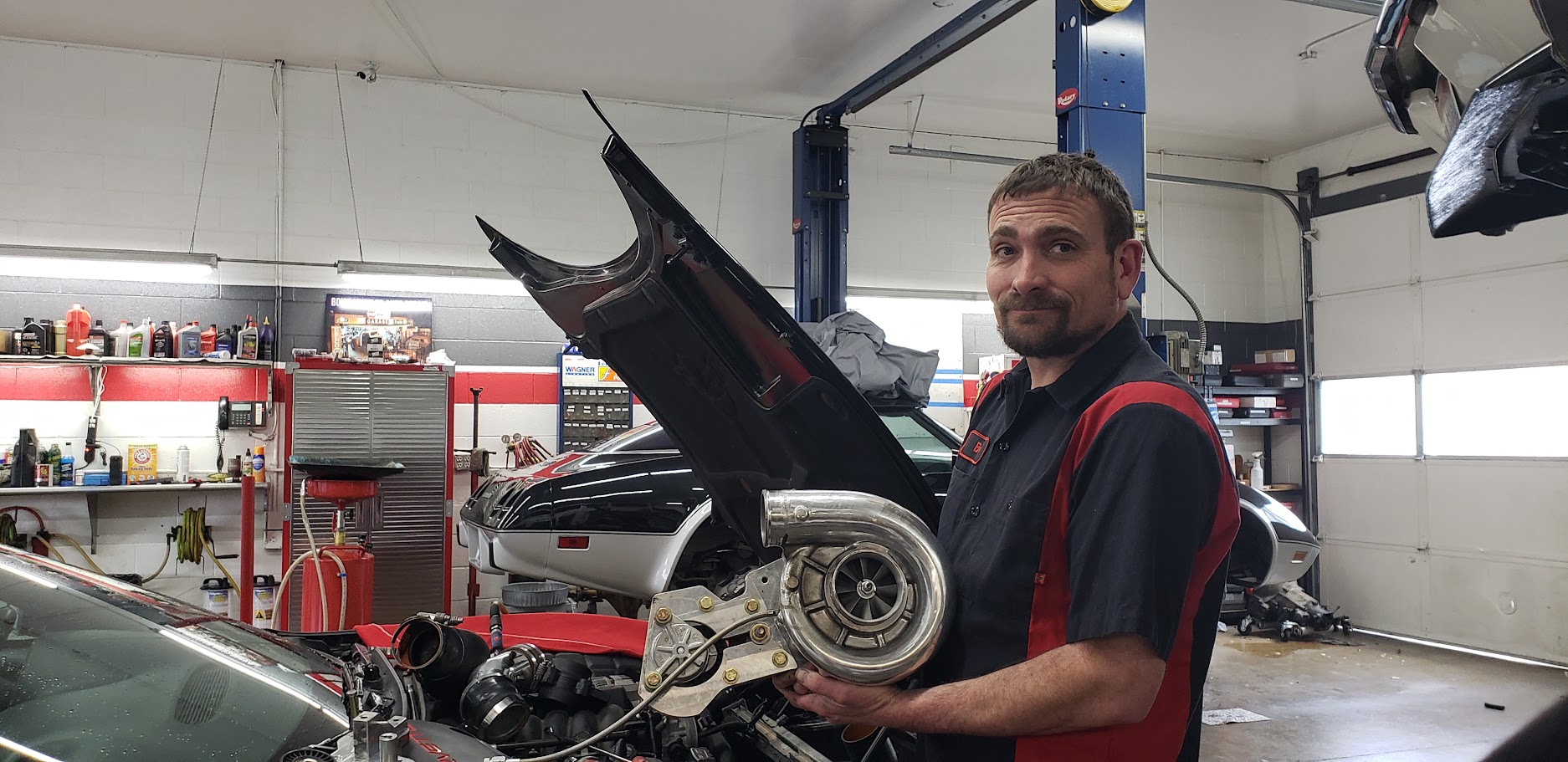 Auto repair technician working on a car engine in Boise auto shop.