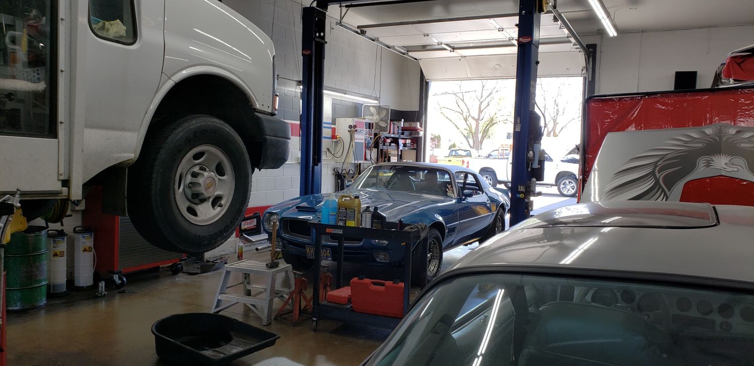 Auto repair shop with vehicles on lifts and tools inside.