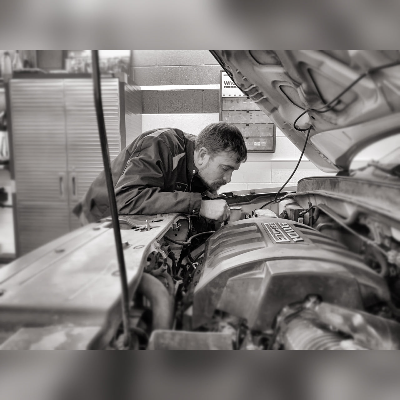 Auto mechanic inspecting engine at Boise Muffler Auto Repair.