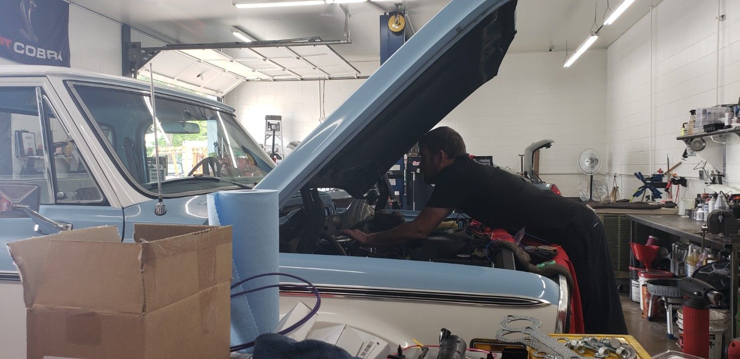 Technician inspecting a vehicle engine at Boise Muffler Auto Repair.