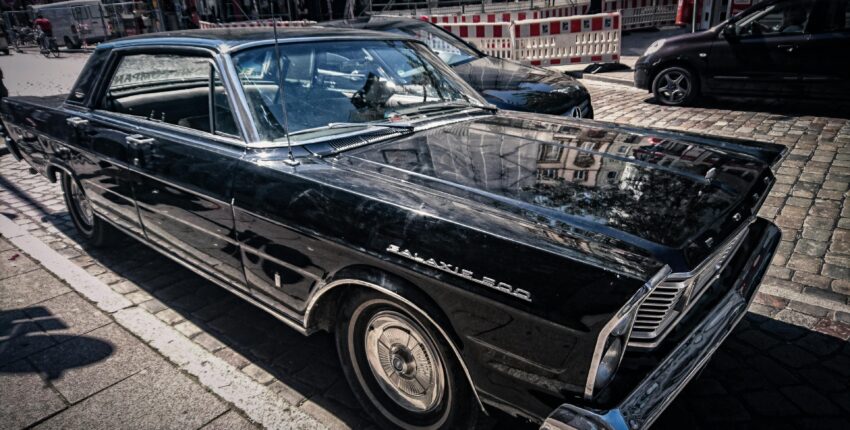 Black vintage car parked on city street near Boise Muffler Auto Repair. Expert auto repair and muffl.